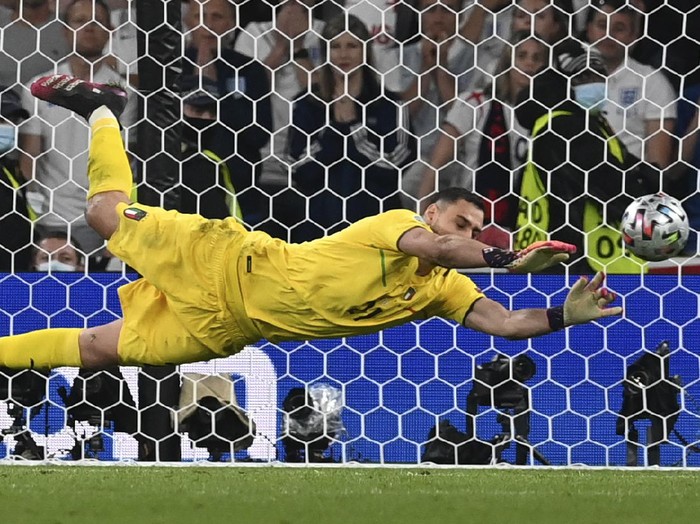 Italy's goalkeeper Gianluigi Donnarumma makes a save against England's Jadon Sancho during penalty shootout of the Euro 2020 soccer championship final match between England and Italy at Wembley Stadium in London, Sunday, July 11, 2021. (Paul Ellis/Pool via AP)