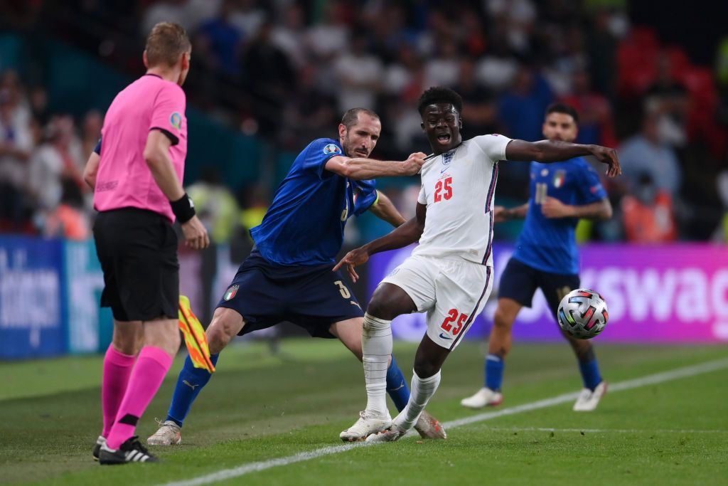 LONDON, ENGLAND - JULY 11: Bukayo Saka of England is fouled by Giorgio Chiellini of Italy during the UEFA Euro 2020 Championship Final between Italy and England at Wembley Stadium on July 11, 2021 in London, England. (Photo by Laurence Griffiths/Getty Images)