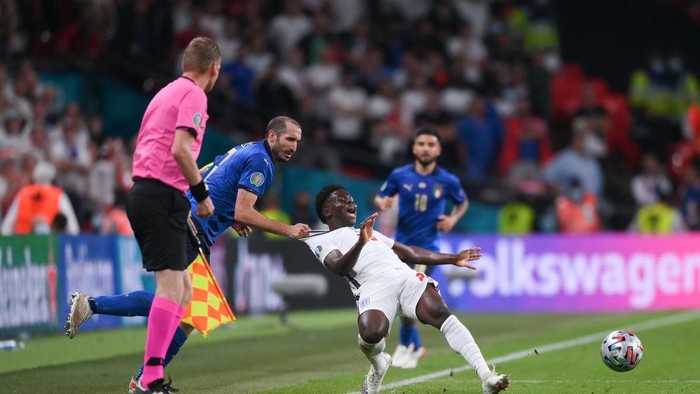 LONDON, ENGLAND - JULY 11: Bukayo Saka of England is fouled by Giorgio Chiellini of Italy during the UEFA Euro 2020 Championship Final between Italy and England at Wembley Stadium on July 11, 2021 in London, England. (Photo by Laurence Griffiths/Getty Images)