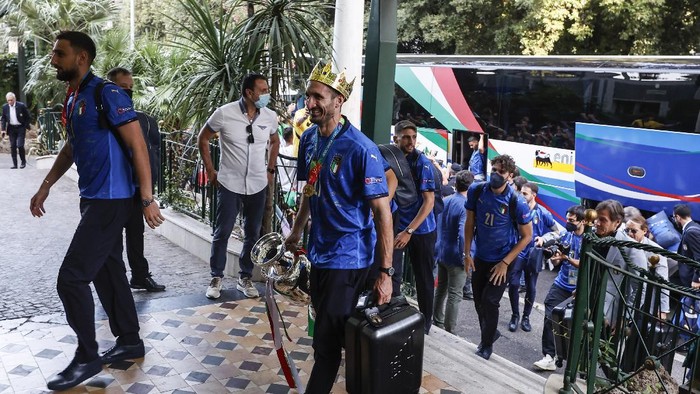 Italys captain Giorgio Chiellini, wearing a crown and holding the trophy, and his teammates arrive at a hotel after returning from London, in Rome, Monday, July 12, 2021. Italy defeated England 3-2 in a penalty shootout after a 1-1 draw, to win the Euro 2020 soccer championships in a final played at Wembley stadium in London on July 11. (AP Photo/Riccardo De Luca)