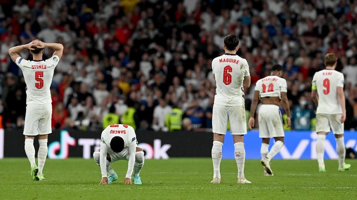 LONDON, ENGLAND - JULY 11: John Stones, Jadon Sancho and Harry Maguire of England look dejected following the UEFA Euro 2020 Championship Final between Italy and England at Wembley Stadium on July 11, 2021 in London, England. (Photo by Paul Ellis - Pool/Getty Images)