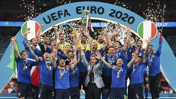 Italy's team celebrates with the trophy on the podium after winning the Euro 2020 soccer championship final between England and Italy at Wembley stadium in London, Sunday, July 11, 2021. (Michael Regan/Pool via AP)