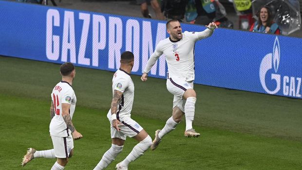 England's Luke Shaw, right, celebrates after scoring his side's opening goal during the Euro 2020 final soccer match between Italy and England at Wembley stadium in London, Sunday, July 11, 2021. (Facundo Arrizabalaga/Pool via AP)
