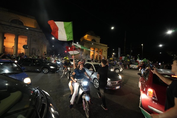 Italys fans celebrate in Milan, Italy, Monday, July 12, 2021, after Italy beat England to win the Euro 2020 soccer championships in a final played at Wembley stadium in London. Italy beat England 3-2 in a penalty shootout after a 1-1 draw. (AP Photo/Luca Bruno)