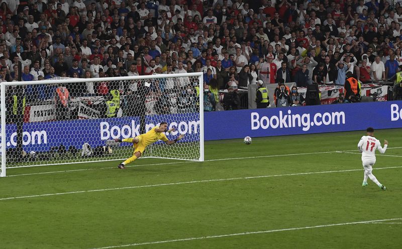 Italy's goalkeeper Gianluigi Donnarumma, left, makes a save in front of England's Jadon Sancho during the penalty shoot out of the Euro 2020 final soccer match between Italy and England at Wembley stadium in London, Sunday, July 11, 2021. (Facundo Arrizabalaga/Pool via AP)