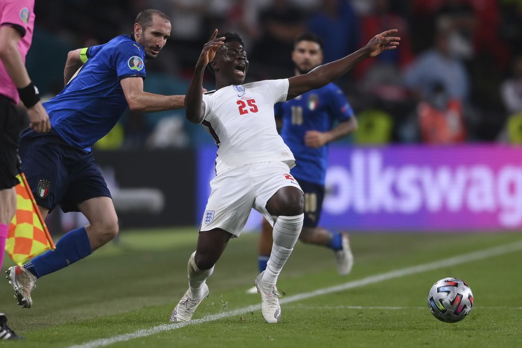 Italy's Giorgio Chiellini, left, stops England's Bukayo Saka during the Euro 2020 soccer final match between England and Italy at Wembley stadium in London, Sunday, July 11, 2021. (Laurence Griffiths/Pool via AP)