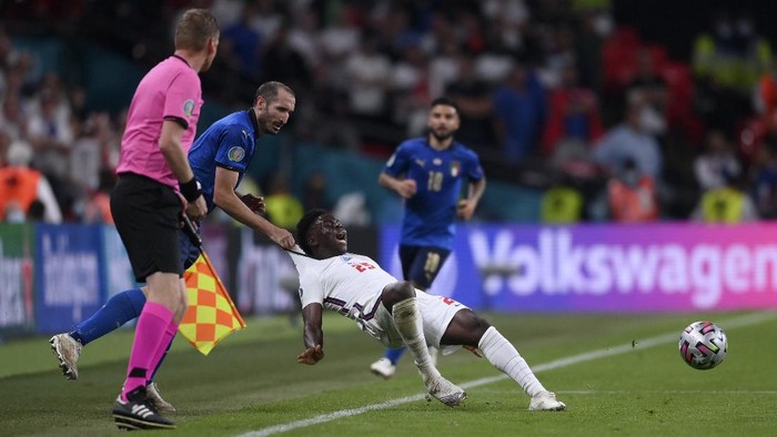 Italys Giorgio Chiellini, left, stops Englands Bukayo Saka during the Euro 2020 soccer final match between England and Italy at Wembley stadium in London, Sunday, July 11, 2021. (Laurence Griffiths/Pool via AP)