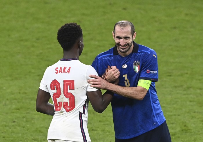 Italy's Giorgio Chiellini, right, shakes hans with England's Bukayo Saka ahead of extra time during the Euro 2020 final soccer match between Italy and England at Wembley stadium in London, Sunday, July 11, 2021. (Facundo Arrizabalaga/Pool via AP)