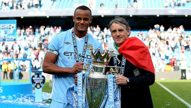 MANCHESTER, ENGLAND - MAY 13:  Vincent Kompany the captain of Manchester City and Roberto Mancini the manager of Manchester City pose with the trophy following the Barclays Premier League match between Manchester City and Queens Park Rangers at the Etihad Stadium on May 13, 2012 in Manchester, England.  (Photo by Alex Livesey/Getty Images)