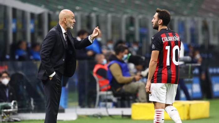 MILAN, ITALY - OCTOBER 17:  AC Milan coach Stefano Pioli issues instructions to his player Hakan Calhanoglu during the Serie A match between FC Internazionale and AC Milan at Stadio Giuseppe Meazza on October 17, 2020 in Milan, Italy.  (Photo by Marco Luzzani/Getty Images)