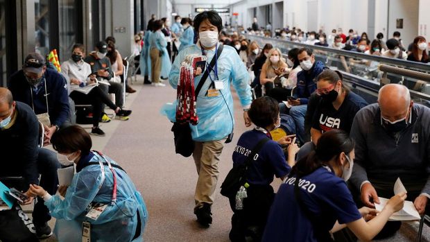Officials wearing personal protection equipment (PPE) prepare to administer the quantitative coronavirus disease (COVID-19) antigen test to the members of the U.S. gymnastics team and other people at Narita International Airport ahead of Tokyo 2020 Olympic Games, in Narita, east of Tokyo, Japan July 15, 2021. REUTERS/Issei Kato