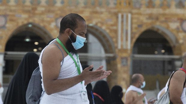 A Muslim pilgrim prays in front of the the Kaaba, the cubic building at the Grand Mosque, as he wears a mask and keeps social distancing, a day before the annual hajj pilgrimage, Saturday, July 17, 2021. The pilgrimage to Mecca required once in a lifetime of every Muslim who can afford it and is physically able to make it, used to draw more than 2 million people. But for a second straight year it has been curtailed due to the coronavirus with only vaccinated people in Saudi Arabia able to participate. (AP Photo/Amr Nabil)