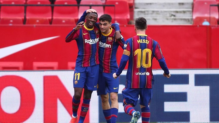SEVILLE, SPAIN - FEBRUARY 27: Ousmane Dembele of FC Barcelona celebrates with team mates Pedri and Lionel Messi after scoring their sides first goal during the La Liga Santander match between Sevilla FC and FC Barcelona at Estadio Ramon Sanchez Pizjuan on February 27, 2021 in Seville, Spain. Sporting stadiums around Spain remain under strict restrictions due to the Coronavirus Pandemic as Government social distancing laws prohibit fans inside venues resulting in games being played behind closed doors. (Photo by Fran Santiago/Getty Images)