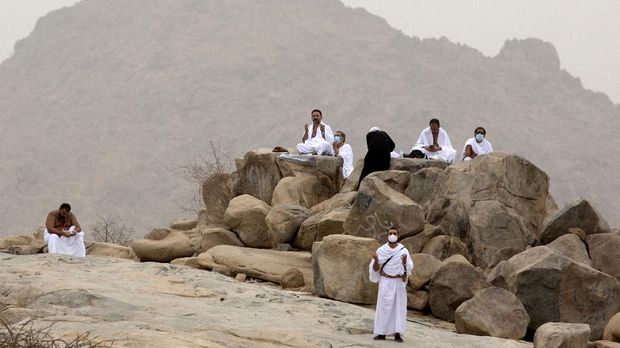 Muslim pilgrims pray near the rocky hill known as Mountain of Mercy, on the Plain of Arafat, during the annual hajj pilgrimage, near the holy city of Mecca, Saudi Arabia, Monday, July 19, 2021. Tens of thousands of vaccinated Muslim pilgrims circled Islam's holiest site in Mecca on Sunday, but remained socially distanced and wore masks as the coronavirus takes its toll on the hajj for a second year running. What once drew some 2.5 million Muslims from all walks of life from across the globe, the hajj pilgrimage is now almost unrecognizable in scale. (AP Photo/Amr Nabil)