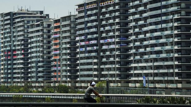 A man rides his bike near the athlete's village for the 2020 Summer Olympics and Paralympics, Thursday, July 15, 2021, in Tokyo. (AP Photo/Jae C. Hong)
