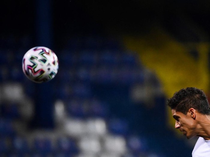 France's defender Raphael Varane heads the ball during the FIFA World Cup Qatar 2022 qualification Group D football match between Bosnia-Herzegovina and France at the Grbavica Stadium, in Sarajevo, on March 31, 2021. (Photo by FRANCK FIFE / AFP)