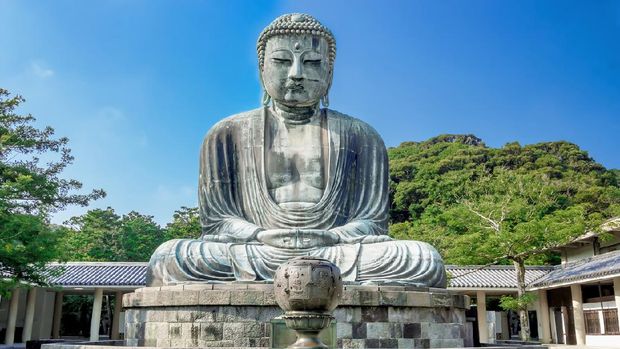 Great Buddha of Kamakura Kamakura, Japan - July 31, 2015: Daibutsu. The Great Buddha of Kotokuin Temple in Kamakura. View of the Great Buddha bronze statue at Kotoku-in temple in Kamakura against a clear blue sky, The second largest bronze Buddha statue in Japan.