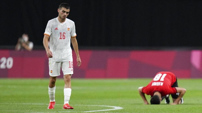 Spains Pedri Gonzalez walks off the field as Egypts Mahmoud El Wench kneels at the end of their 0-0 draw during a mens soccer match at the 2020 Summer Olympics, Thursday, July 22, 2021, in Sapporo, Japan. (AP Photo/SIlvia Izquierdo)