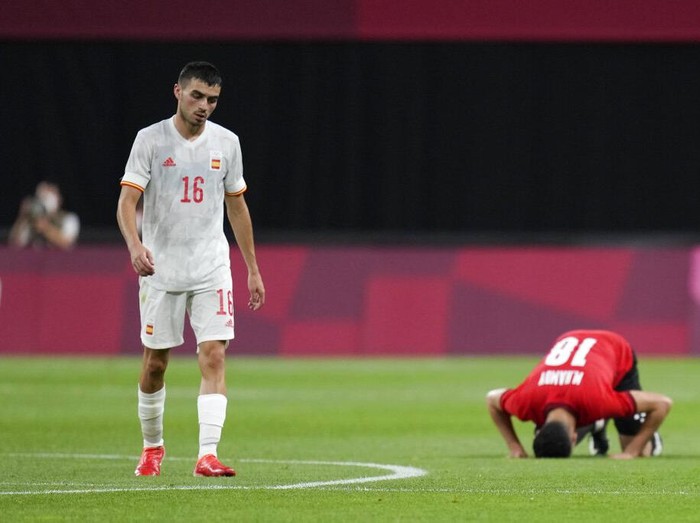 Spains Pedri Gonzalez walks off the field as Egypts Mahmoud El Wench kneels at the end of their 0-0 draw during a mens soccer match at the 2020 Summer Olympics, Thursday, July 22, 2021, in Sapporo, Japan. (AP Photo/SIlvia Izquierdo)