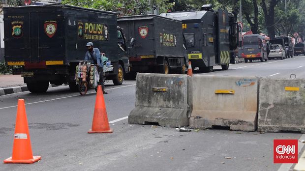 Warga berjalan di dekat kawat berduri di kawasan Harmoni, Jakarta, Sabtu, 24 Juli 2021. Kepolisian menyiapkan kawat berduri di kawasan Harmoni untuk mengantisipasi adanya massa aksi yang akan melakukan unjuk rasa terkait penolakan perpanjangan pemberlakuan pembatasan kegiatan masyarakat (PPKM). CNN Indonesia/Adhi Wicaksono