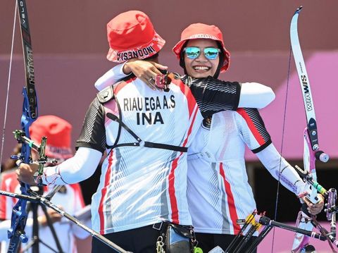 Indonesia's Diananda Choirunisa (R) and Riau Salsabila celebrate after beating the USA in the mixed team eliminations during the Tokyo 2020 Olympic Games at Yumenoshima Park Archery Field in Tokyo on July 24, 2021. (Photo by ADEK BERRY / AFP)