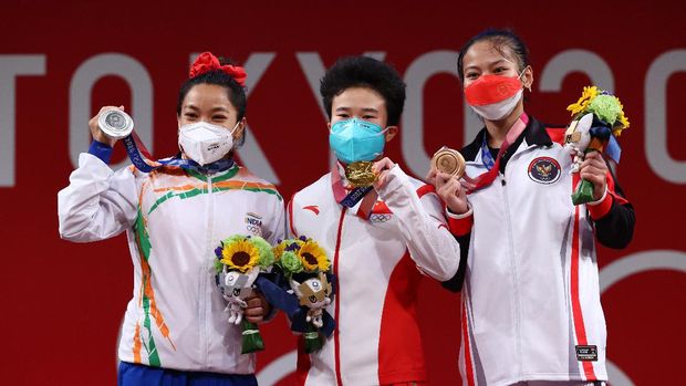 Tokyo 2020 Olympics - Weightlifting - Women's 49kg - Medal Ceremony - Tokyo International Forum, Tokyo, Japan - July 24, 2021. Gold medalist Hou Zhihui of China, Silver medalist Mirabai Chanu Saikhom of India and Bronze medalist Windy Cantika Aisah of Indonesia pose. REUTERS/Edgard Garrido