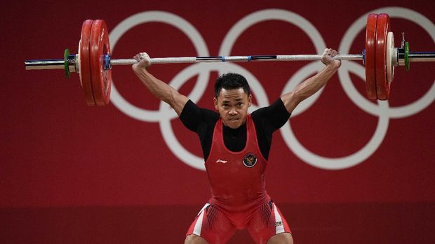 Eco Yuli Irawan of Indonesia competes in the men's 61kg weightlifting event, at the 2020 Summer Olympics, Sunday, July 25, 2021, in Tokyo, Japan. (AP Photo/Luca Bruno)