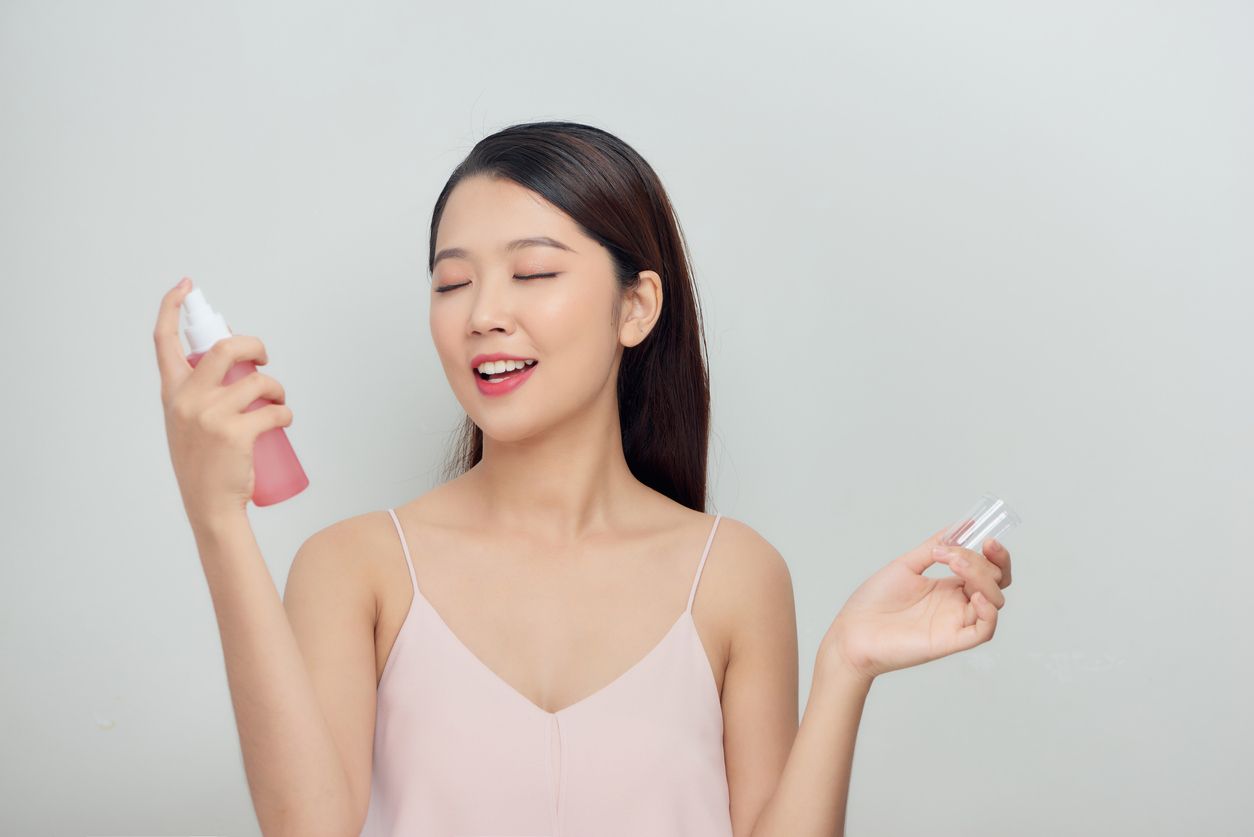 Beautiful woman face spray on face lotion cosmetology on white background isolation