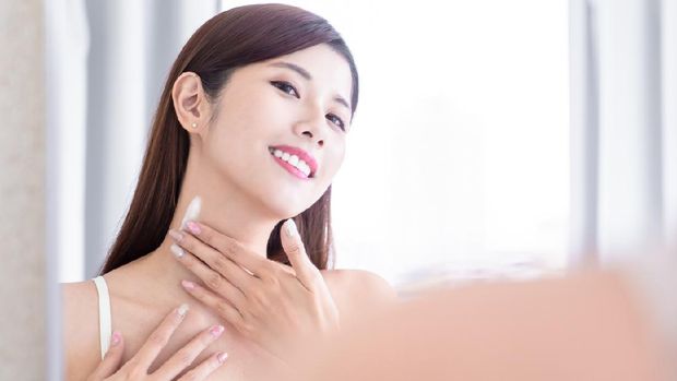 asian  beauty woman apply lotion on her neck in the bathroom