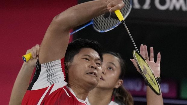Indonesia's Praveen Jordan and Melati Daeva Oktavianti play against Japan's Yuta Watanabe and Arisa Higashino during their mixed doubles group play stage badminton match at the 2020 Summer Olympics, Monday, July 26, 2021, in Tokyo, Japan. (AP Photo/Markus Schreiber)