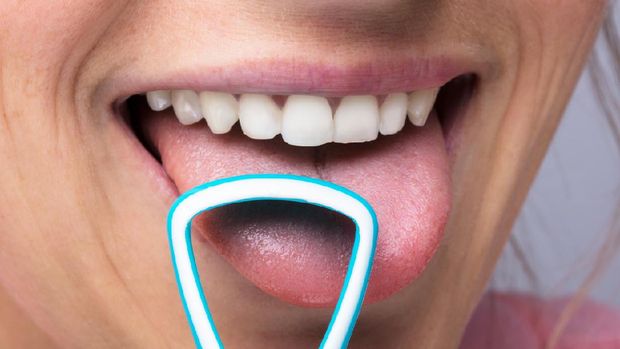 Close-up Of Young Woman Cleaning Tongue With Cleaner