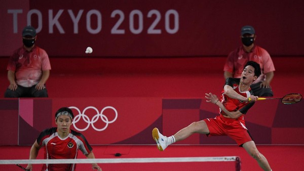 Ganda putra Indonesia Marcus Fernaldi Gideon/Kevin Sanjaya Sukamuljo mengembalikan kok ke arah ganda putra Taiwan Yang Lee/Chi-Lin Wang dalam penyisihan Grup A Olimpiade Tokyo 2020 di Musashino Forest Sport Plaza, Tokyo, Jepang, Selasa (27/7/2021). Marcus dan Kevin kalah 18-21, 21-15, 17-21 dari ganda putra Taiwan. ANTARA FOTO/Sigid Kurniawan/hp.