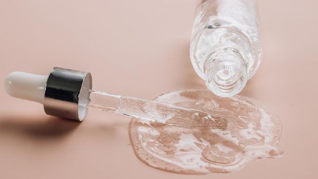 ilustrasi serum ampoule: Bottle of hyaluronic acid on skin color background with oxygen bubbles. Selective focus