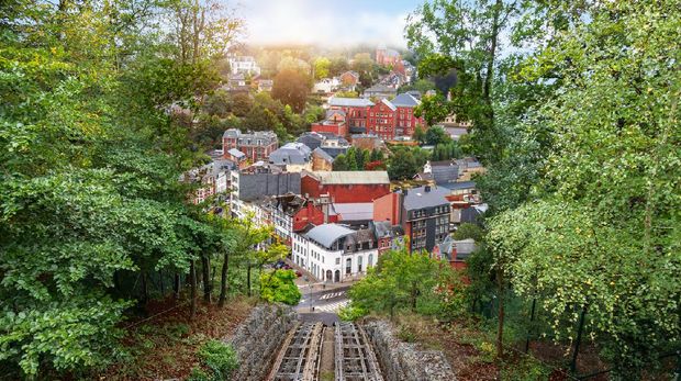 Spa di Belgia Aerial view of city of Spa. View from above, rail track of cable car at the Thermes in Spa. Green trees on the side. Panoramic landscape with city.