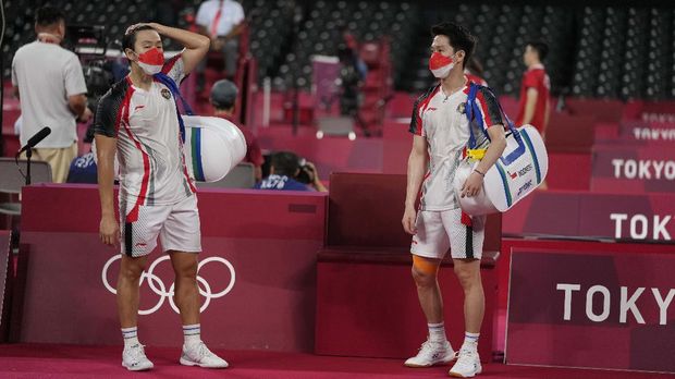 Indonesia's Marcus Fernaldi Gideon, left, and Kevin Sanjaya Sukamuljo react after beaten by Malaysia's Aaron Chia and Soh Wooi Yik in their men's doubles quarterfinal match at the 2020 Summer Olympics, Thursday, July 29, 2021, in Tokyo, Japan. (AP Photo/Markus Schreiber)