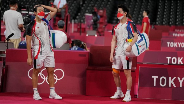 Indonesias Marcus Fernaldi Gideon, left, and Kevin Sanjaya Sukamuljo react after beaten by Malaysias Aaron Chia and Soh Wooi Yik in their mens doubles quarterfinal match at the 2020 Summer Olympics, Thursday, July 29, 2021, in Tokyo, Japan. (AP Photo/Markus Schreiber)