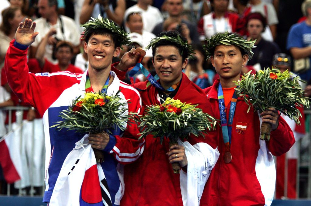 ATHENS - AUGUST 21:  (L-R) Seung Mo Shon of Korea (silver), Taufik Hidayat of Indonesia (gold) and Soni Dwi Kuncoro of Indonesia (bronze) celebrate after receiving medals  for the men's singles badminton event on August 21, 2004 during the Athens 2004 Summer Olympic Games at Olympic Hall in the Goudi Olympic Complex in Athens, Greece. (Photo by Jonathan Ferrey/Getty Images)