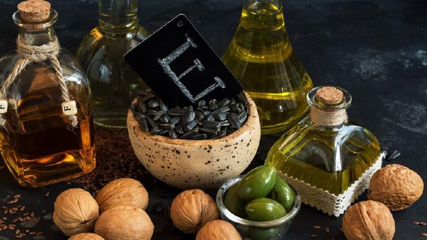 Close-up of products with vitamin E. Olive oil, linseed, walnut and sunflower on a black concrete background. Selective focus