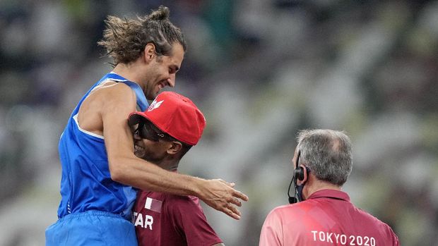 Gianmarco Tamberi, of Italy celebrates with Mutaz Barshim of Qatar after they won joint gold in the final of the men's high jump at the 2020 Summer Olympics, Sunday, Aug. 1, 2021, in Tokyo, Japan. (AP Photo/Martin Meissner)