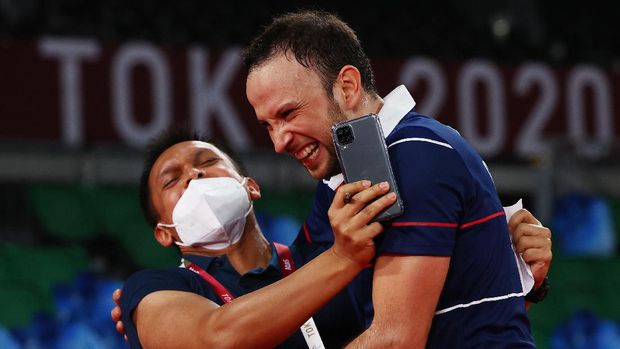 Tokyo 2020 Olympics - Badminton - Men's Singles - Last 16 - MFS - Musashino Forest Sport Plaza, Tokyo, Japan – July 29, 2021. Kevin Cordon of Guatemala celebrates winning the match against Mark Caljouw of the Netherlands with coach Muamar Qadafi. REUTERS/Leonhard Foeger