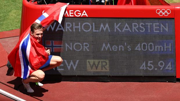 Tokyo 2020 Olympics - Athletics - Men's 400m Hurdles - Final - Olympic Stadium, Tokyo, Japan - August 3, 2021. Karsten Warholm of Norway poses next to his new world record as he celebrates after winning gold. REUTERS/Andrew Boyers
