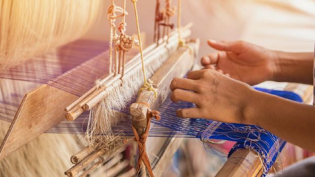 Wheel Spinning Yarn with Yellow Thread to work for Weaving machine and Thai traditional Silk. Artists artisans handicrafts handmade manufacturing motton silk hand loom Thai.