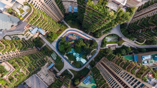 Kota-kota Hijau di seluruh dunia This aerial photo taken on July 12, 2021 shows apartment blocks with balconies covered with plants at a residential community in Chengdu in China's southwestern Sichuan province. - Green spaces have also been shown to improve health and wellbeing, including reducing stress, anxiety and depression, improving attention and focus, better physical health and managing Post Traumatic Stress Disorder. (Photo by STR / AFP) / China OUT / TO GO WITH Environment-climate-cities,FEATURE
