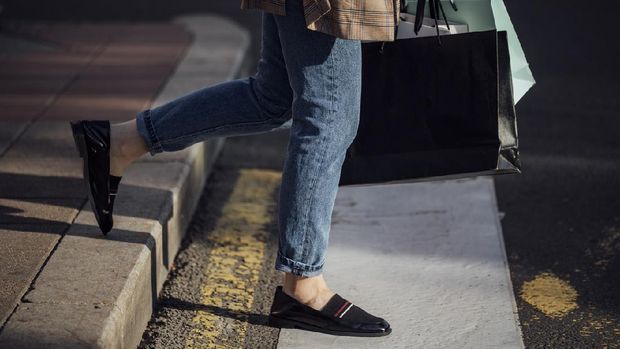 Cropped shot of an anonymous woman carrying paper shopping bags.