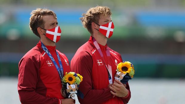 YOKOHAMA, JAPAN - JULY 27: Shimeng Peng #12 of Team China wears a face mask with teammates as they stand for the national anthem prior to the Women's Group F match between Netherlands and China on day four of the Tokyo 2020 Olympic Games at International Stadium Yokohama on July 27, 2021 in Yokohama, Kanagawa, Japan. (Photo by Francois Nel/Getty Images)