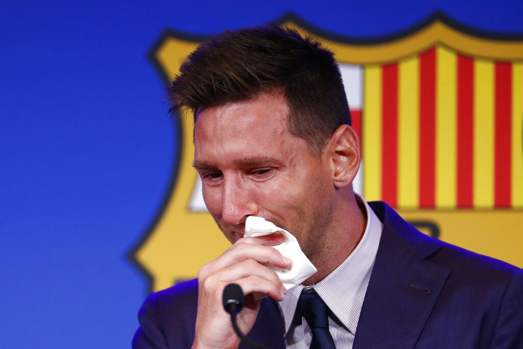 The statue of Barcelona's former player and coach Johan Cruyff, in front of a mural of Lionel Messi outside the Camp Nou stadium in Barcelona, Spain, Thursday, Aug. 5, 2021. Barcelona announced Thursday that Messi will not stay with the club, saying that the Spanish league's financial regulations made it impossible to sign the Argentina star to a new contract. (AP Photo/Joan Monfort)