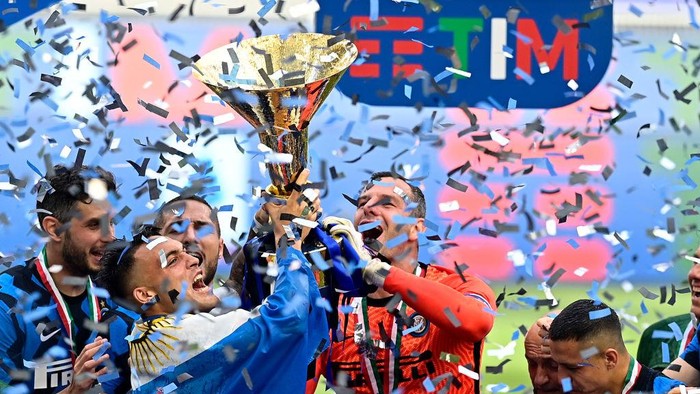 MILAN, ITALY - MAY 23: Samir Handanovic of FC Internazionale lifts the Serie A Trophy whilst his team mates celebrate after the Serie A match between FC Internazionale Milano and Udinese Calcio at Stadio Giuseppe Meazza on May 23, 2021 in Milan, Italy. Sporting stadiums around Italy remain under strict restrictions due to the Coronavirus Pandemic as Government social distancing laws prohibit fans inside venues resulting in games being played behind closed doors (Photo by Mattia Ozbot/Getty Images)