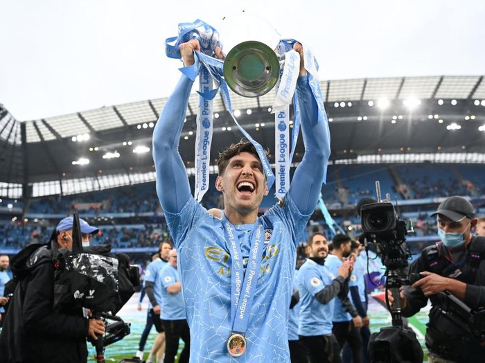 MANCHESTER, ENGLAND - MAY 23: John Stones celebrates with the Premier League Trophy as Manchester City are presented with the Trophy as they win the league following the Premier League match between Manchester City and Everton at Etihad Stadium on May 23, 2021 in Manchester, England. A limited number of fans will be allowed into Premier League stadiums as Coronavirus restrictions begin to ease in the UK. (Photo by Michael Regan/Getty Images)