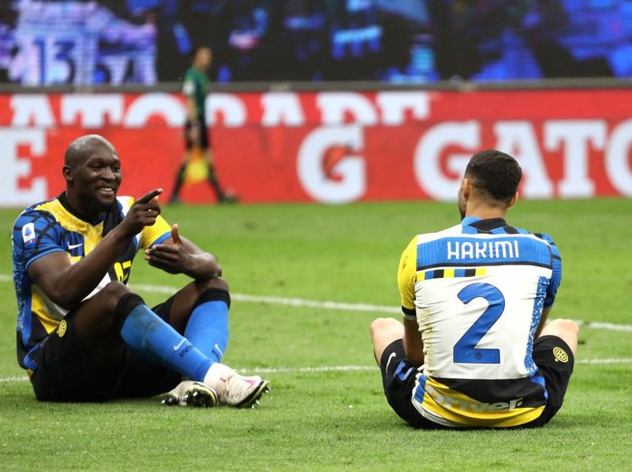 MILAN, ITALY - MAY 12: Romelu Lukaku of FC Internazionale celebrates after scoring their sides third goal with team mate Achraf Hakimi during the Serie A match between FC Internazionale and AS Roma at Stadio Giuseppe Meazza on May 12, 2021 in Milan, Italy. Sporting stadiums around Italy remain under strict restrictions due to the Coronavirus Pandemic as Government social distancing laws prohibit fans inside venues resulting in games being played behind closed doors.  (Photo by Marco Luzzani/Getty Images)