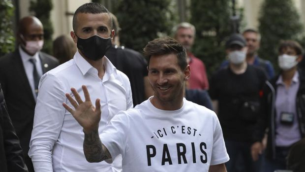 Argentinian soccer star Lionel Messi waves to supporters as he arrives at his hotel in Paris, Tuesday, Aug. 10, 2021. Lionel Messi finalized agreement on his Paris Saint-Germain contract and arrived in the French capital on Tuesday to complete the move that confirms the end of a career-long association with Barcelona. (AP Photo/Adrienne Surprenant)